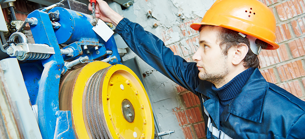 elevator mechanic adjusting elevator mechanism of lift with spanner